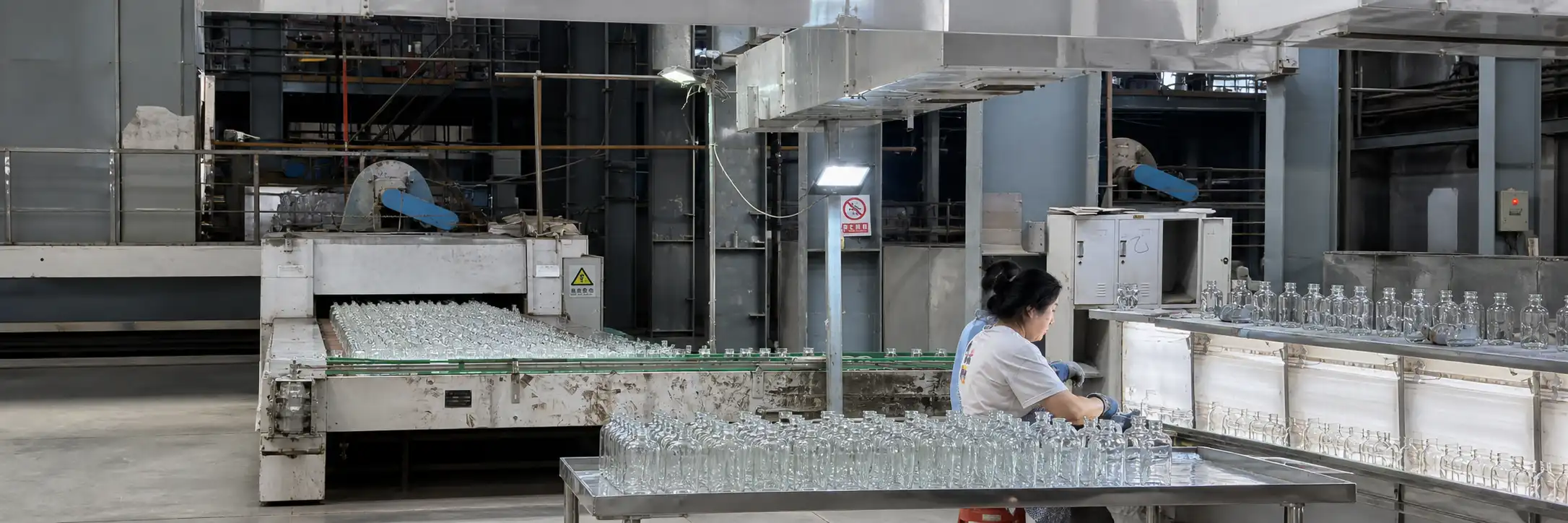HangoTech workers inspecting glass bottles during production